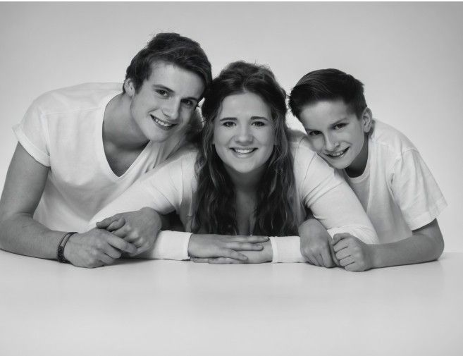 A black-and-white studio portrait of John with Elizabeth and Robert as teenagers