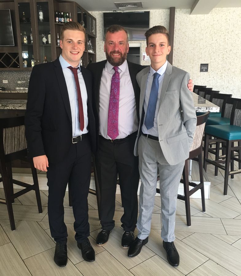 John with his father and his brother Robert, all in suits